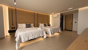 a bedroom with two beds with white sheets and lights at Hotel Lepanto Reforma in Mexico City +63 photos