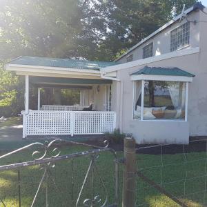 una casa bianca con una grande finestra e un portico di 37 Valley View Cottage a Underberg