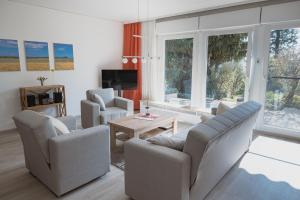 a living room with couches and a table and windows at Casa La Vie Ferienwohnungen in Altenstadt
