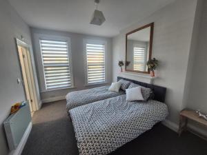 a bedroom with a bed with a mirror and windows at Castle View Dover in Dover