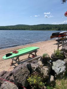 a green surfboard sitting on a picnic table on the beach at The Boardwalk in Westfield Beach