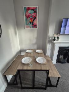 a wooden table with plates on it in a room with a fireplace at Castle View Dover in Dover
