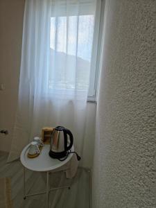 a tea kettle on a table in front of a window at Lone Star Apartments in Gusinje