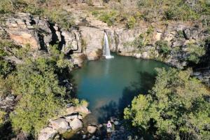 an aerial view of a lake with a waterfall at Casa de piscina em Delfinopolis área central 2 suítes in Delfinópolis