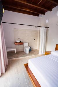 a bedroom with a bed and a sink and a toilet at Casa Manglares Capurganá in Acanti