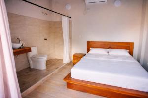a bedroom with a bed and a bathroom with a toilet at Casa Manglares Capurganá in Acanti +38 photos