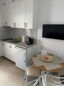 a kitchen with white cabinets and a table and a sink at Alexander in Ierissos +1 photo