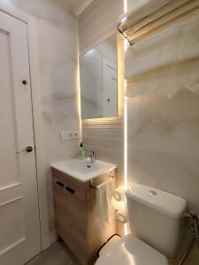 a bathroom with a white toilet and a sink at Albatros centro Lucena in Lucena +15 photos