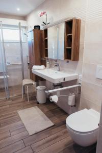 a bathroom with a sink and a toilet at Casa La Vie Ferienwohnungen in Altenstadt +62 photos