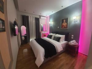 a bedroom with a large bed with pink lighting at Apartament Fbi in Athens