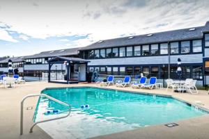 a large swimming pool with chairs and a building at Splash & Relax Unit 203 in Wells