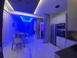 a kitchen with purple lighting and a table and chairs at Apartament Fbi in Athens +12 photos