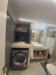 a bathroom with a washing machine and a sink at Apartament Fbi in Athens