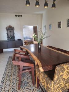 a dining room with a wooden table and a couch at Santuario del Sol in Mérida