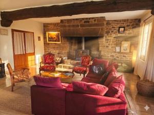 a living room with a couch and a stone fireplace at Bed and Breakfast Saultchevreuil in Villedieu-les-Poêles