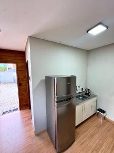 a kitchen with a stainless steel refrigerator in a room at Pousada Barcelos Florianópolis in Florianópolis