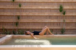 a woman laying on the edge of a swimming pool at Jiloo Beautiful Oasis in Punta Zicatela 3 in Brisas de Zicatela