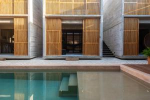 a house with wooden doors and a swimming pool at Jiloo Beautiful Oasis in Punta Zicatela 3 in Brisas de Zicatela