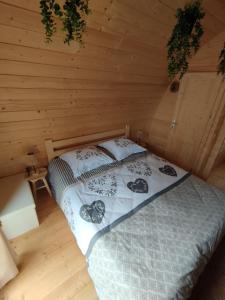 a bedroom with a bed in a wooden cabin at Au petit chalet in Meisenthal