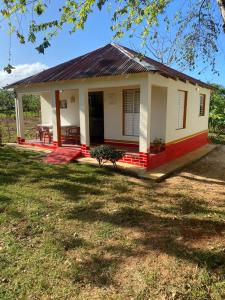 a small house with a red and white at las casitas acogedora in Las Galeras +6 photos