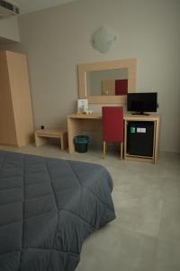a room with a bed and a desk and a red chair at Hotel Panorama in Cambiano