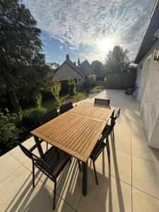 a wooden table and chairs on a patio at Maison 3ch proche circuit 24h et boulerie jump in Saint Pavace