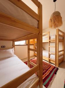 a room with two bunk beds and a chandelier at Swellora Surf Camp Imsouane in Imsouane +195 photos