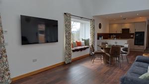 a living room with a couch and a dining room at Cottages Lyndale Farm in Flashader
