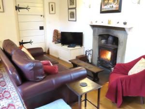 a living room with a couch and a fireplace at Welsh Gatehouse A Historic Castle Retreat that Welcomes Dogs and Electric Vehicles in Mathern