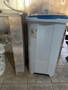 a white trash can with a blue lid sitting on a floor at Casa de piscina em Delfinopolis área central 2 suítes in Delfinópolis