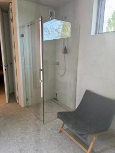 a glass shower with a chair in a room at The Box in Sint-Pieters-Leeuw