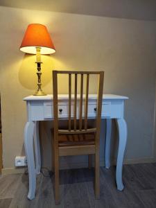 a white desk with a lamp and a chair at Huis van Rooi Willebringen in Boutersem