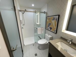 a bathroom with a shower and a toilet and a sink at Le Grand Hotel St-Georges in Saint-Georges