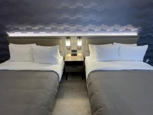two beds sitting next to each other in a room at Le Grand Hotel St-Georges in Saint-Georges