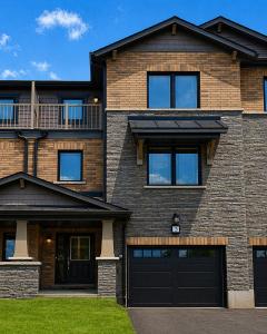 a large brick house with two garage doors at Nordic Three Brantford in Brantford