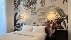 a bedroom with a large bed with a floral wallpaper at Logis Hôtel Restaurant Grand Hôtel de Lyon in Vals-les-Bains +100 photos
