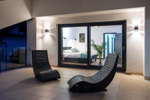 a room with two chairs and a bed in a bedroom at Slotvin Apartments in Słotwiny