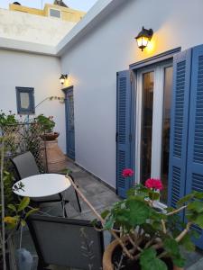 a patio with blue doors and a table and flowers at BlueHouse III in Palekastron