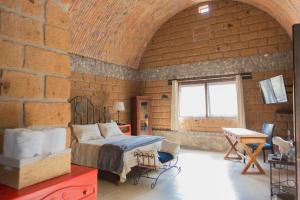 ein Schlafzimmer mit einem Bett und einer Ziegelwand in der Unterkunft Armadillo Mágico in Armadillo