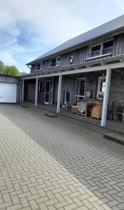 a brick building with tables and chairs in front of it at Franzenhof Beldorf in Beldorf