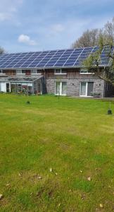a building with solar panels on top of a field at Franzenhof Beldorf in Beldorf