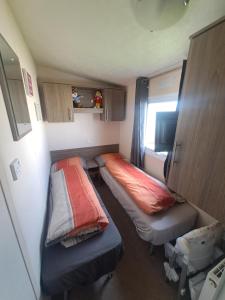 a small room with two beds and a window at Trecco Bay Cwtch Caravan in Newton +22 photos