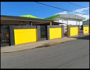 a building with yellow doors on the side of a street at Humacao Guest House 2 in Humacao