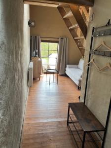 a room with a bed and a table and a mirror at Aux Sabots du Temps in Vielsalm