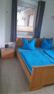 a bedroom with a bed with blue pillows and a window at Franzenhof Beldorf in Beldorf +8 photos