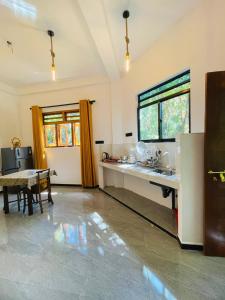 a kitchen with a sink and a table in a room at Mond Villa Weligama - Private Surf & Nature Stay near Beach in Weligama