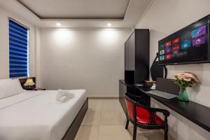 a bedroom with a bed and a desk with a computer at Trung Mai Sân Bay T3 in Ho Chi Minh City