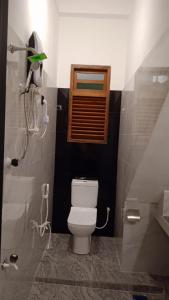 a small bathroom with a toilet and a shower at Mond Villa Weligama - Private Surf & Nature Stay near Beach in Weligama +2 photos