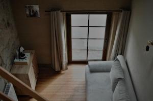 a living room with a couch and a large window at Aux Sabots du Temps in Vielsalm