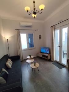 a living room with a couch and a tv at BlueHouse III in Palekastron